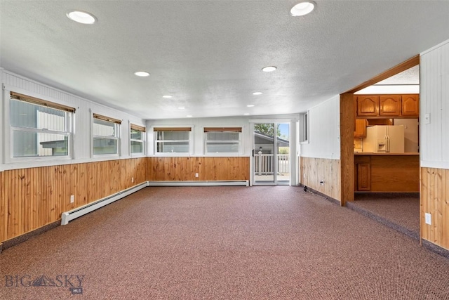 509 1st E, Whitehall, MT 59759 - unfurnished room featuring wooden walls, dark carpet, a textured ceiling, wainscoting, and recessed lighting