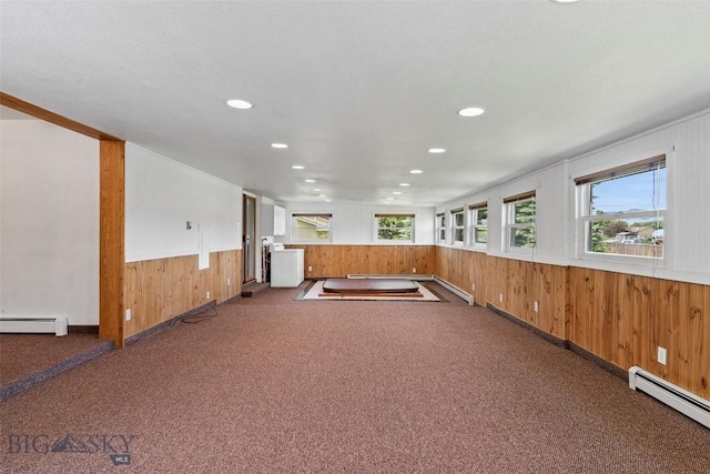 509 1st E, Whitehall, MT 59759 - empty room featuring a baseboard radiator, carpet floors, wooden walls, recessed lighting, and a wainscoted wall