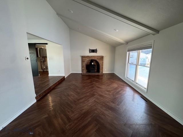 1421 Bluebird Ln, Bozeman, MT 59715 - unfurnished living room with baseboards and a brick fireplace