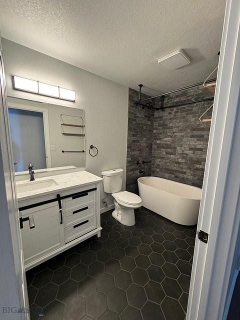 full bathroom featuring tile patterned floors, a textured ceiling, vanity, a freestanding tub, and a tile shower