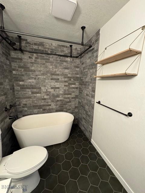 1421 Bluebird Ln, Bozeman, MT 59715 - bathroom featuring tile patterned floors, tiled shower, and a textured ceiling