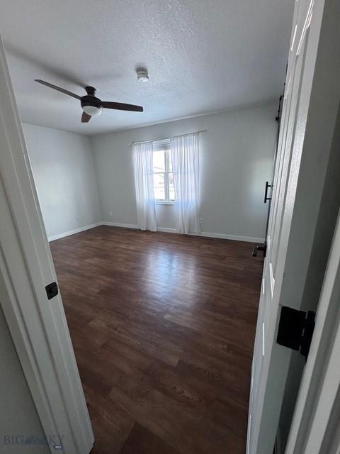 1421 Bluebird Ln, Bozeman, MT 59715 - unfurnished room with dark wood-style flooring, a ceiling fan, and a textured ceiling