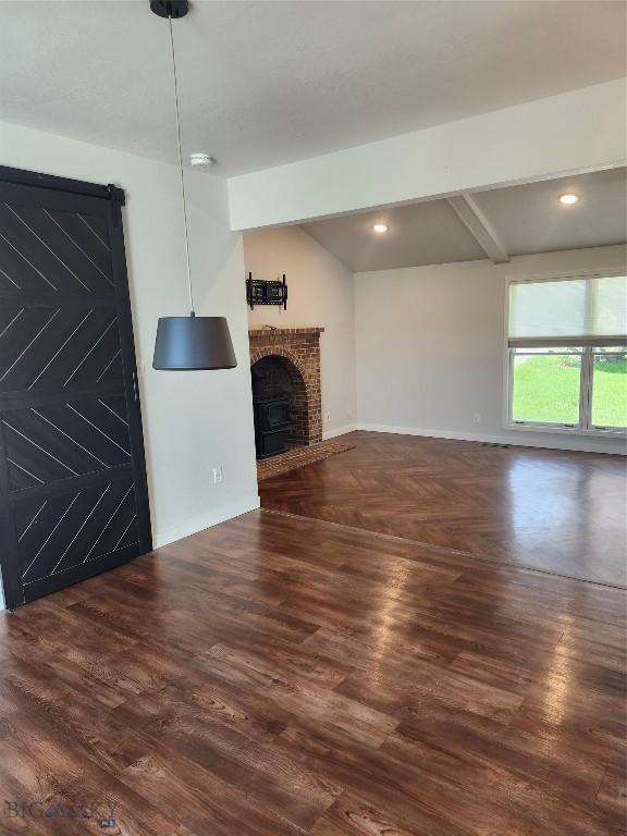 1421 Bluebird Ln, Bozeman, MT 59715 - unfurnished living room with wood finished floors, a brick fireplace, beamed ceiling, and recessed lighting