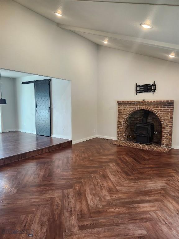 1421 Bluebird Ln, Bozeman, MT 59715 - unfurnished living room with vaulted ceiling, a wood stove, and recessed lighting