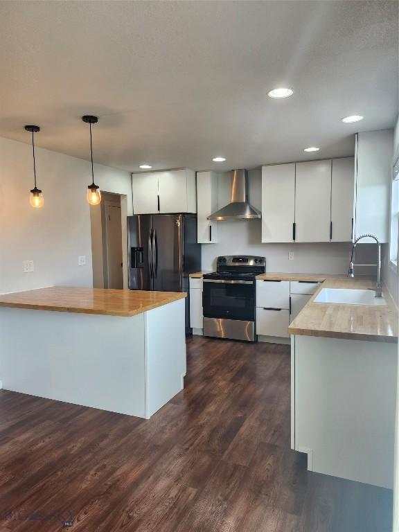 1421 Bluebird Ln, Bozeman, MT 59715 - kitchen with stainless steel stove, wall chimney range hood, fridge with ice dispenser, dark wood-style floors, and pendant lighting