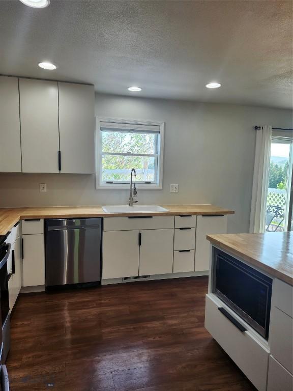 1421 Bluebird Ln, Bozeman, MT 59715 - kitchen with stainless steel appliances, dark wood-style flooring, recessed lighting, white cabinets, and a textured ceiling