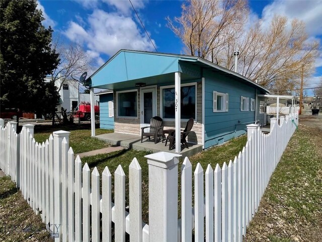 307 W Legion St, Whitehall, MT 59759 - bungalow-style house with a front yard, a porch, and a fenced front yard