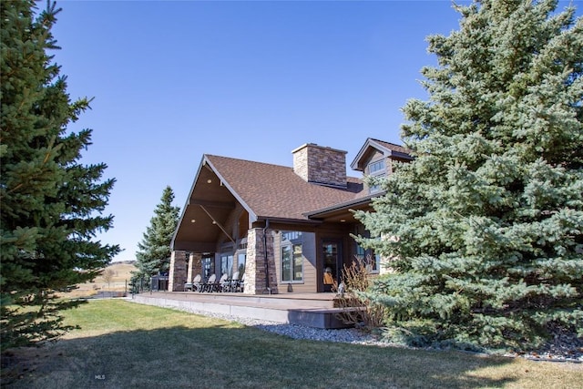 10 Wood Duck Rd, Ennis, MT 59729 - rear view of property with a lawn, a chimney, roof with shingles, and stone siding