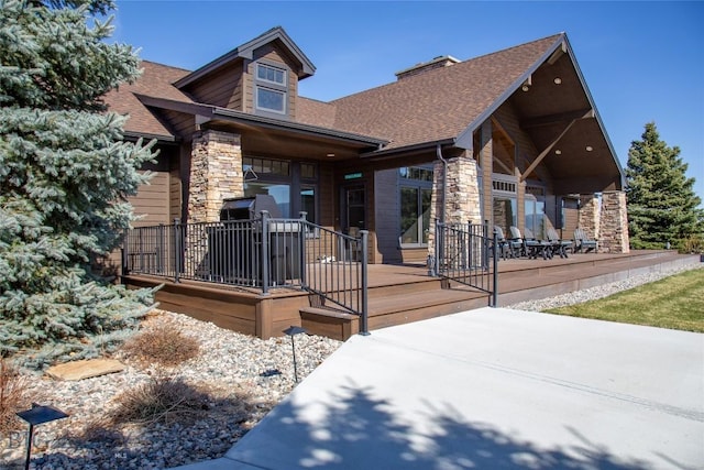 10 Wood Duck Rd, Ennis, MT 59729 - view of front of house with stone siding, roof with shingles, a chimney, and a patio area