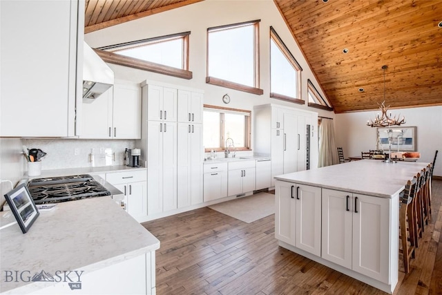 10 Wood Duck Rd, Ennis, MT 59729 - kitchen featuring wood ceiling, premium range hood, light wood-style floors, high vaulted ceiling, and a kitchen island