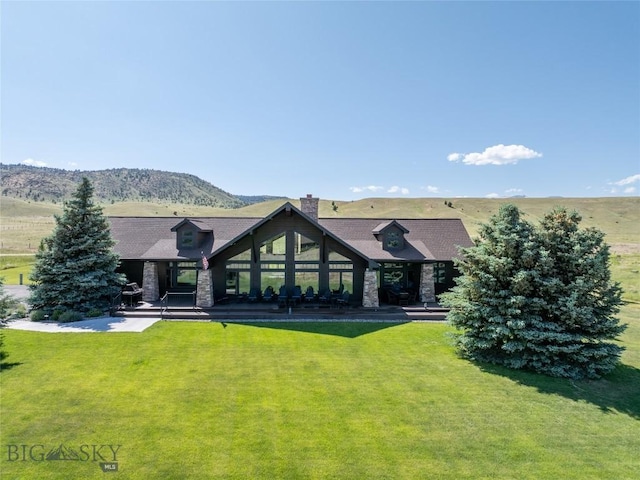 10 Wood Duck Rd, Ennis, MT 59729 - rear view of house featuring a yard, a chimney, and stone siding