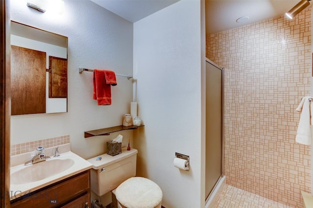 full bath featuring toilet, vanity, decorative backsplash, and a stall shower