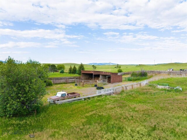 view of yard with a rural view, an exterior structure, and an outbuilding