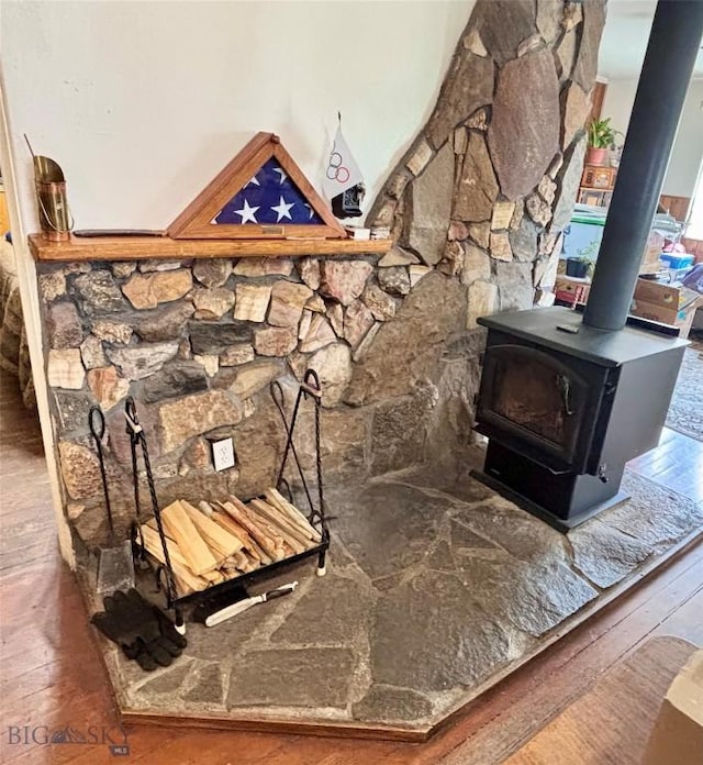 details featuring a wood stove and wood finished floors