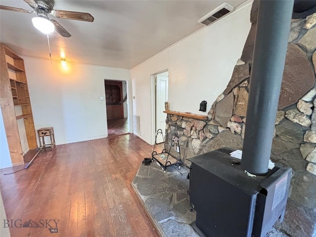 113 N Pacific St, Dillon, MT 59725 - living area with a wood stove, hardwood / wood-style floors, ceiling fan, and crown molding