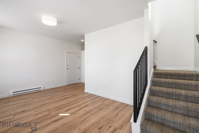 staircase with a baseboard heating unit, wood finished floors, baseboards, and recessed lighting