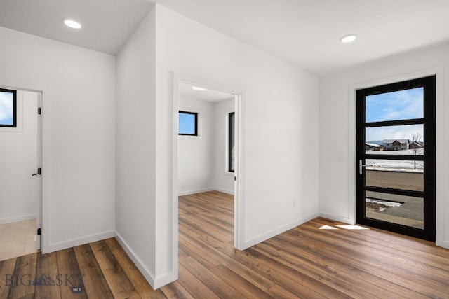 foyer entrance featuring baseboards, wood finished floors, and recessed lighting