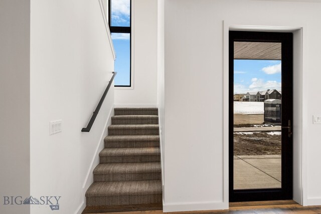 stairs with wood finished floors and baseboards