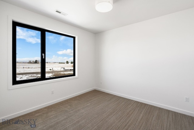 spare room with baseboards, carpet flooring, and visible vents