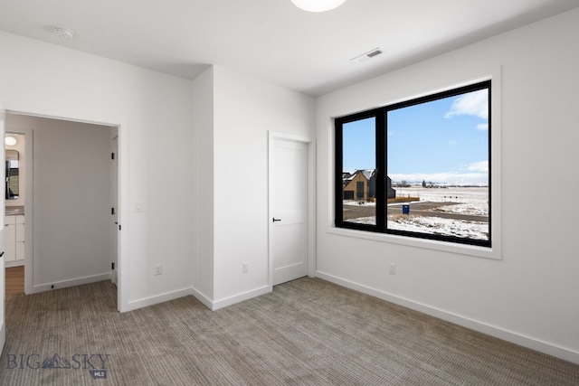 unfurnished bedroom featuring visible vents, baseboards, and light carpet