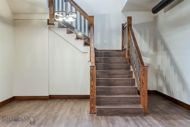 stairs featuring wood finished floors and baseboards
