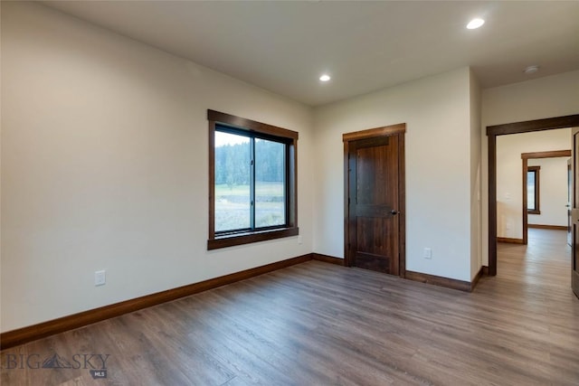 unfurnished bedroom with baseboards, wood finished floors, and recessed lighting