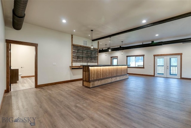 unfurnished living room featuring visible vents, baseboards, recessed lighting, wood finished floors, and indoor wet bar