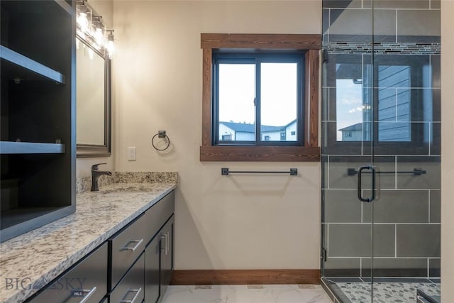 bathroom featuring baseboards, marble finish floor, vanity, and a stall shower