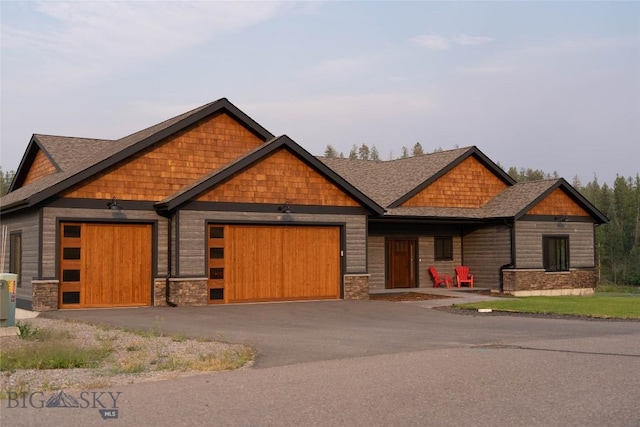 craftsman-style home featuring a garage and aphalt driveway