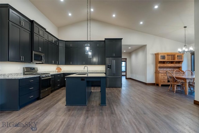 kitchen featuring dark wood finished floors, stainless steel appliances, pendant lighting, a kitchen island with sink, and high vaulted ceiling