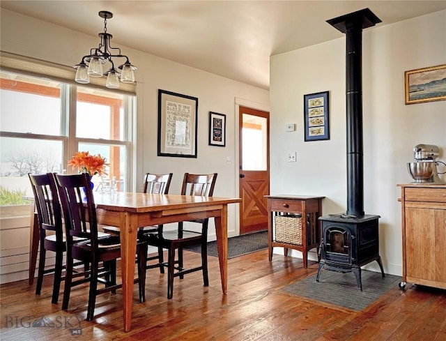 657 Waterloo Rd, Whitehall, MT 59759 - dining area featuring a wood stove, dark wood-type flooring, and a chandelier