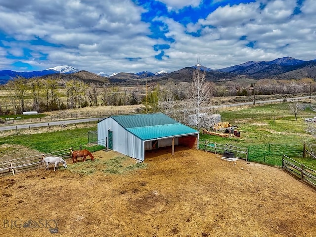view of pole building featuring an exterior structure, a mountain view, and a rural view