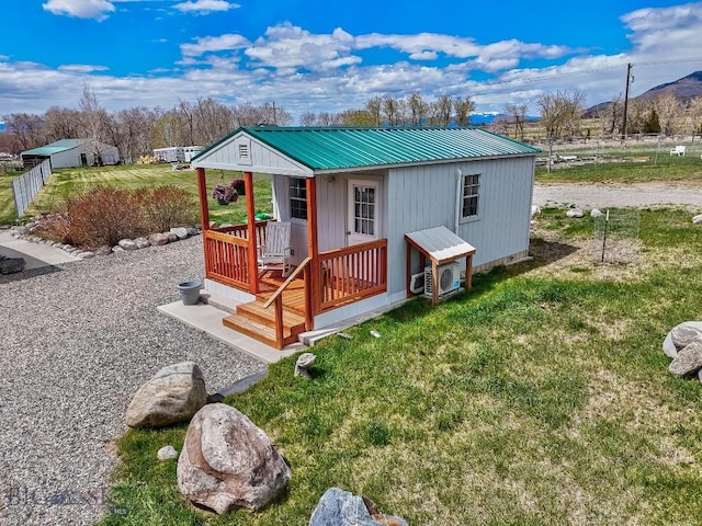view of front of home with an outdoor structure, a front yard, a mountain view, and metal roof