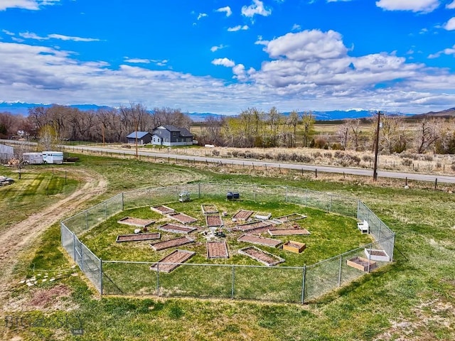 view of yard featuring a vegetable garden, fence, and a mountain view