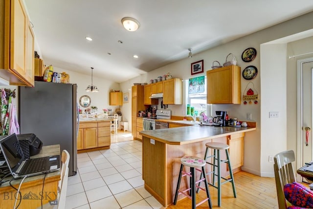 kitchen with recessed lighting, white electric stove, a kitchen breakfast bar, freestanding refrigerator, and a peninsula