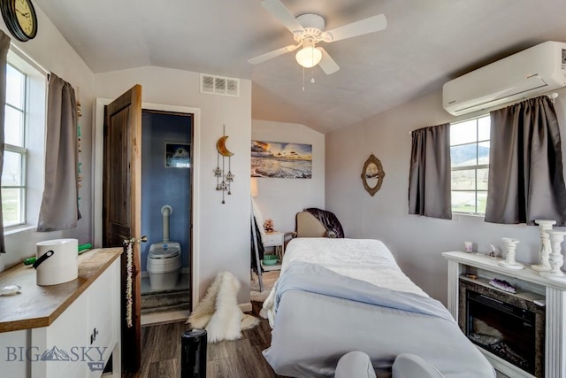 bedroom with a wall mounted AC, ceiling fan, lofted ceiling, dark wood-style flooring, and visible vents