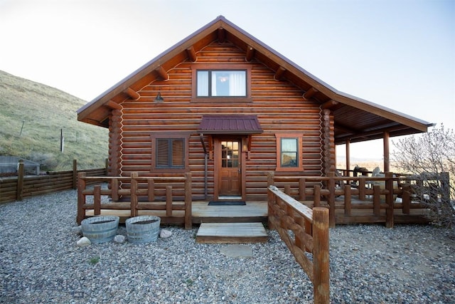 cabin featuring a deck with mountain view and log siding