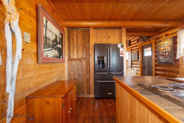 kitchen featuring tile counters, stainless steel appliances, wood ceiling, log walls, and dark wood-style flooring