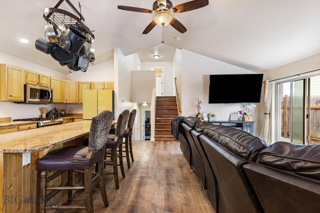 250 Jackson Ln, Belgrade, MT 59714 - living area featuring vaulted ceiling, a ceiling fan, stairway, and wood finished floors