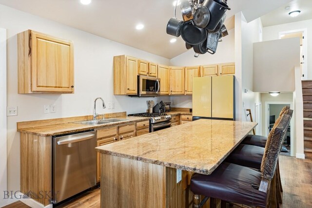 250 Jackson Ln, Belgrade, MT 59714 - kitchen with appliances with stainless steel finishes, a sink, light brown cabinetry, light wood-style flooring, and vaulted ceiling