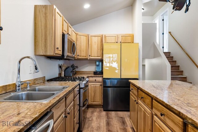 250 Jackson Ln, Belgrade, MT 59714 - kitchen featuring stainless steel appliances, a sink, vaulted ceiling, dark wood-style flooring, and light brown cabinetry