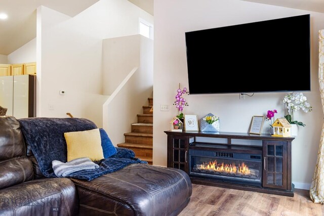 250 Jackson Ln, Belgrade, MT 59714 - living area with light wood-style flooring, lofted ceiling, stairway, and a glass covered fireplace