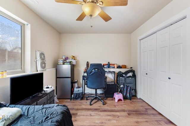 250 Jackson Ln, Belgrade, MT 59714 - bedroom featuring freestanding refrigerator, wood finished floors, a closet, and ceiling fan
