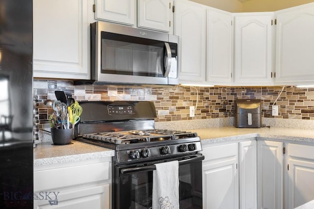 kitchen with white cabinets, black appliances, and tasteful backsplash