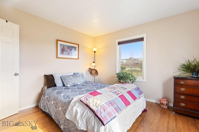 bedroom featuring baseboards and wood finished floors