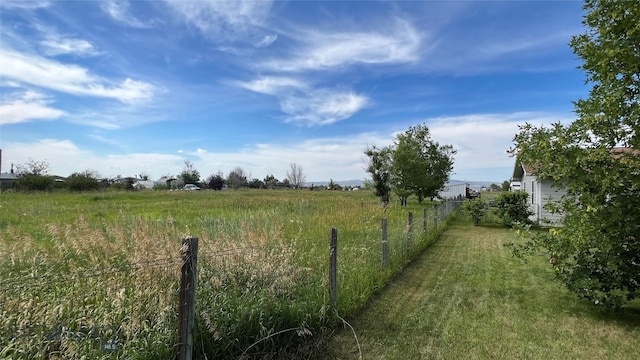 view of yard with a rural view and fence