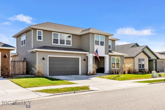 traditional home featuring driveway, fence, a front lawn, an attached garage, and a shingled roof