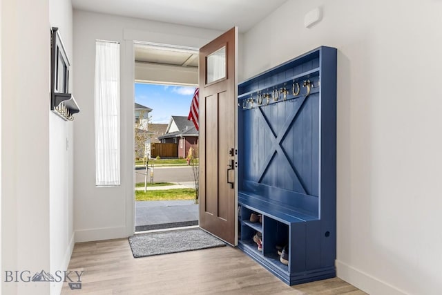 entryway with baseboards and wood finished floors