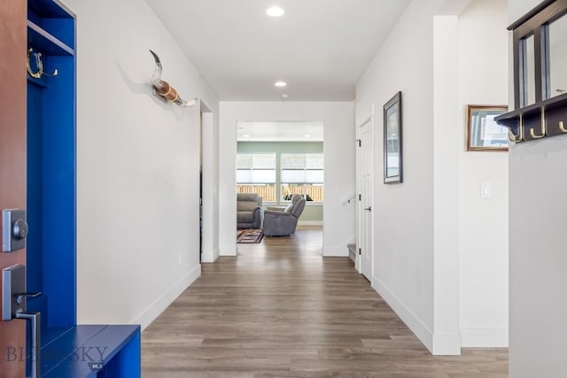 corridor featuring baseboards, recessed lighting, and wood finished floors
