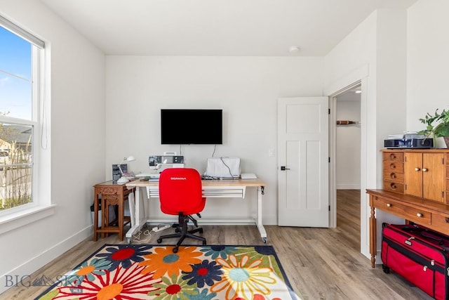 office area with a healthy amount of sunlight, baseboards, and wood finished floors